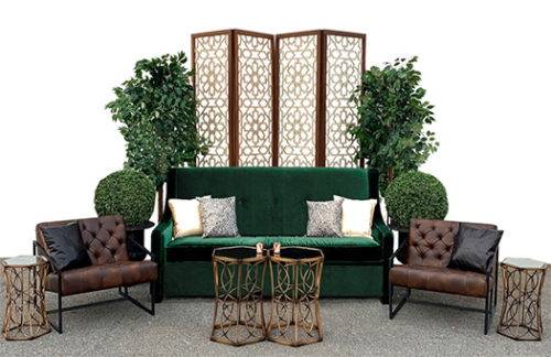 Seating group with green sofa, brown leather chairs, and gold coffee table and end tables